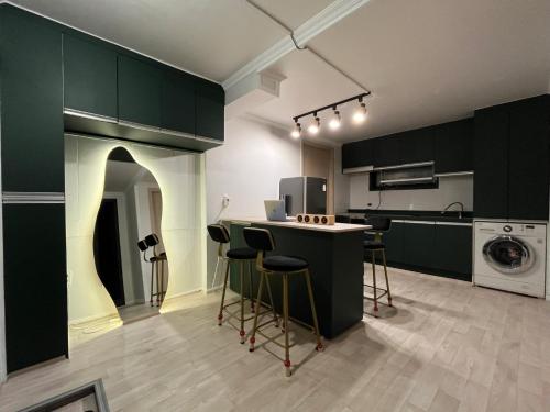 a kitchen with green cabinets and a counter with stools at Green house room 101 in Seoul