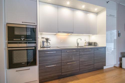 a kitchen with stainless steel appliances and wooden cabinets at LEVI Tunturinlaita A4, Ski-in Ski-out 3xBedroom in Levi