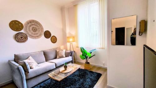 ein Wohnzimmer mit einem Sofa und einem Tisch in der Unterkunft KosyKasa SPA in Cannes