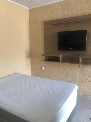 a bedroom with a bed and a flat screen tv at Pousada Patriarca Silva in Rio Grande