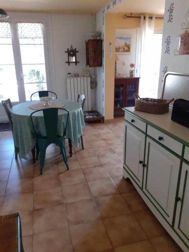 une cuisine avec une table et un tissu de table vert dans l'établissement Gite Bienvenue Lili, à Châteauneuf-de-Gadagne