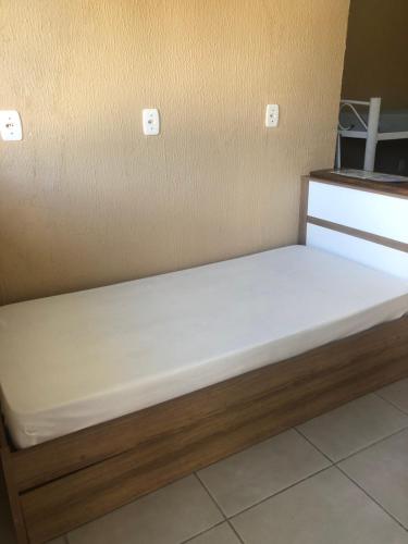 a bed in the corner of a room at Pousada Patriarca Silva in Rio Grande