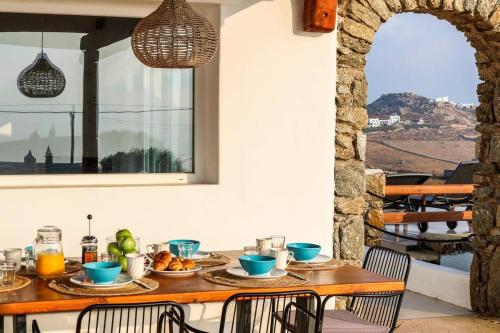 a table with food on it in a room with a window at Luxury White Oasis Villa w Private Pool in Mikonos in Kalafatis