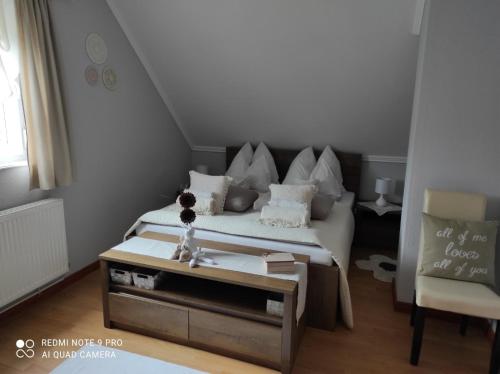 Pusztavár-Lak في Erdőhorváti: غرفة نوم صغيرة مع سرير وطاولة