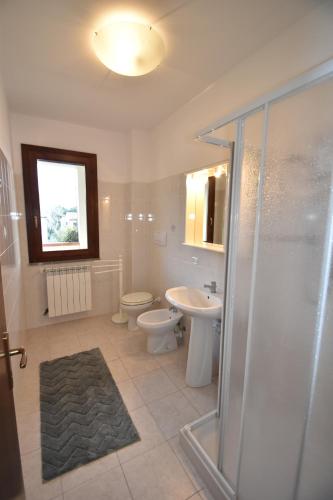a bathroom with a shower and a toilet and a sink at Trilocale Lacona Mare - Zona mare con clima e posto auto in Lacona