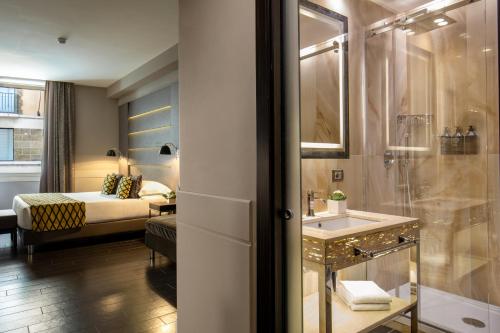 a bathroom with a shower and a sink and a bed at The Style in Rome