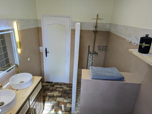 La salle de bains est pourvue d'un lavabo et d'une croix sur le mur. dans l'établissement Sweet Home Dordogne between Sarlat-Souillac, à Peyrillac-et-Millac