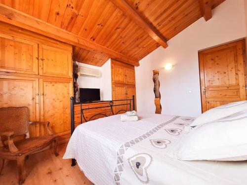 um quarto com uma cama branca e um tecto de madeira em Bas de villa avec Piscine et Terrasse au calme em Contes