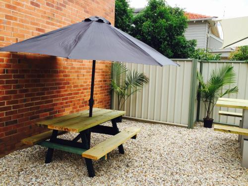 a picnic table with an umbrella on a patio at Civic Motel Grafton in Grafton