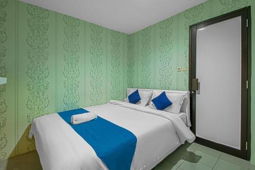 a bedroom with a large bed with green walls at HOUSE MUSE in Siantan
