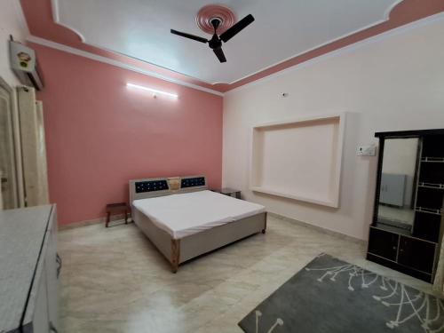 a bedroom with a bed and a ceiling fan at Astha Homes in Varanasi