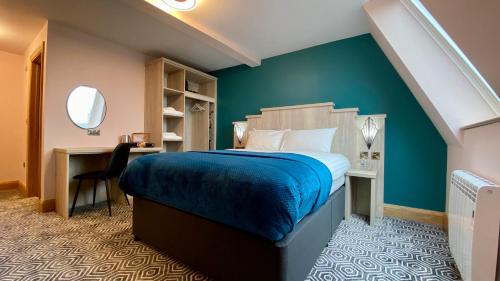 a bedroom with a bed and a desk with a mirror at The Bath Rooms in Morecambe