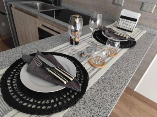 a table with two plates and wine glasses on a counter at Best Apartment Rental Estación Central in Santiago
