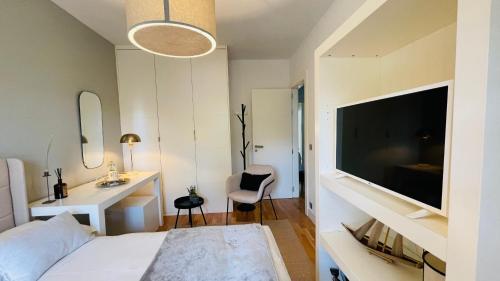 Schlafzimmer mit einem Bett, einem Schreibtisch und einem TV in der Unterkunft Estilosa casa golf in Gorraiz