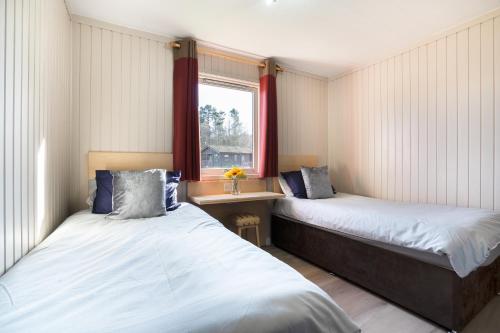 2 letti in una piccola camera con finestra di Lodge -3 Bedrooms - Hunters Quay a Kilmun