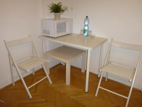 - un bureau avec deux chaises, un four micro-ondes, une table et des chaises dans l'établissement M Apartments - Downtown, à Budapest