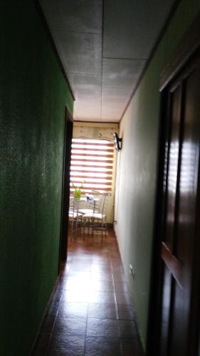 a hallway with a table and a green wall at Boutique Hotel Casa Orquídeas in San José