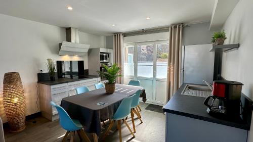 a kitchen and dining room with a table and chairs at La Maison Blanche in Sangatte