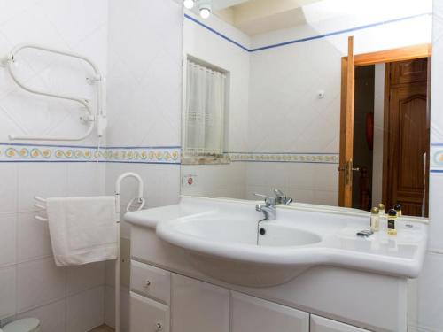 a white bathroom with a sink and a mirror at Joia da Galé House - Pool and Garden & BBQ & Galé Beach in Albufeira