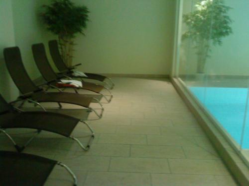 a row of chairs in a room with a window at Modernes Appartment, 3 Gehminuten zum Strand, Pool+Sauna in Zempin