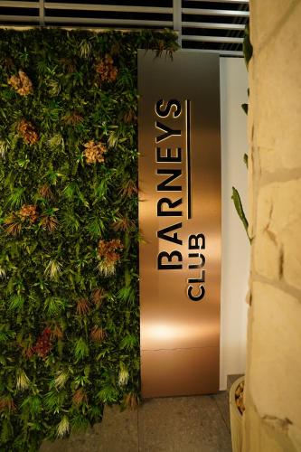 a wall covered in plants with a sign on it at Barneys B&b in Cercola