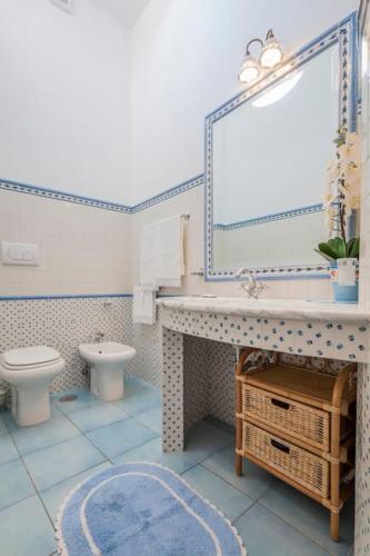 a bathroom with a sink and a toilet and a mirror at Divina Costiera Praiano in Praiano