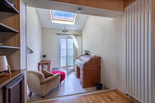 a living room with a piano and a chair at Villa Les Sources - Les pieds dans l'eau in Lugrin