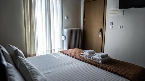 a bedroom with a bed with towels on it at Rooms Batalogianni in Kalabaka