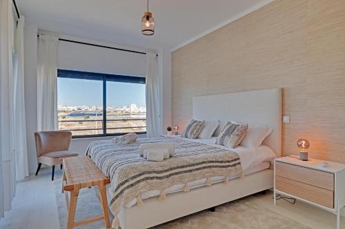 1 dormitorio con cama grande y ventana grande en Casa Ferraguido by Portucasa, en Ferragudo