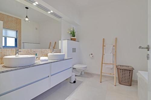 La salle de bains est pourvue de 2 lavabos et de toilettes. dans l'établissement Casa Ferraguido by Portucasa, à Ferragudo