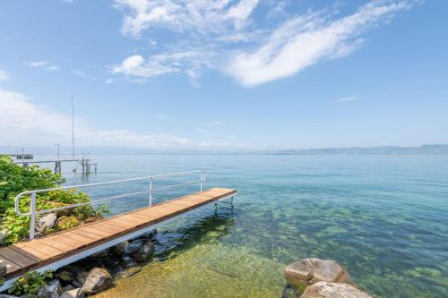 a dock in the middle of a large body of water at Villa Les Sources - Les pieds dans l'eau in Lugrin