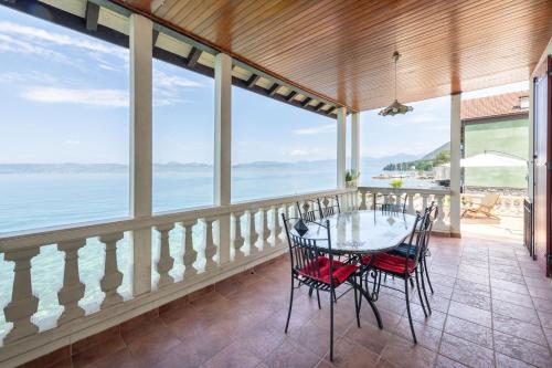 a dining room with a glass table and chairs at Villa Les Sources - Les pieds dans l'eau in Lugrin