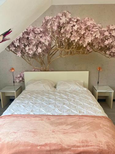 une chambre avec un arbre aux fleurs roses sur le mur dans l'établissement [Rêve Rose] Studio Équipé, Wifi, Vue, à Lourdes