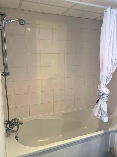 La salle de bains est pourvue d'une baignoire et d'un rideau. dans l'établissement [Rêve Rose] Studio Équipé, Wifi, Vue, à Lourdes
