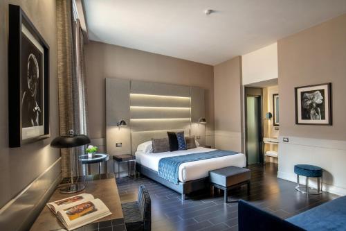 ローマにあるThe Styleのベッドとテーブルが備わるホテルルームです。