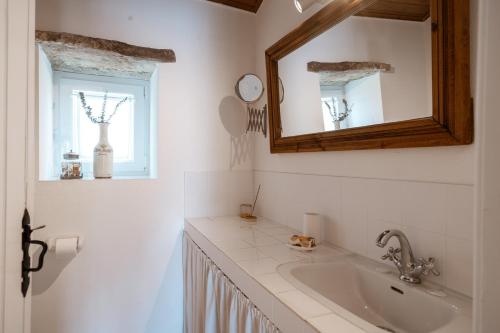 baño con lavabo, espejo y ventana en Refugio d'Alma, en Mafra