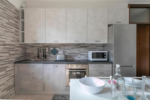 a kitchen with white cabinets and a white bowl on a counter at Casa Miri - Padova in Padova