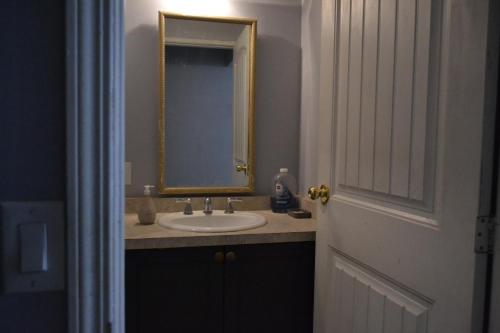 y baño con lavabo y espejo. en Private Bedroom on the main floor with shared washroom - Erin Woods en Calgary