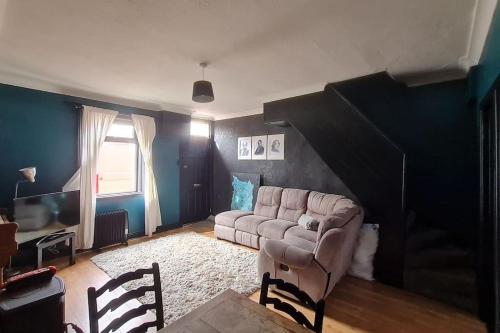 ein Wohnzimmer mit einem Sofa und einem Tisch in der Unterkunft Little house in the City in Dublin