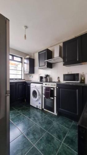 eine Küche mit einer Waschmaschine und einer Waschmaschine in der Unterkunft Little house in the City in Dublin