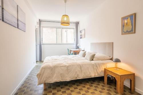 une chambre avec un grand lit et une table dans l'établissement Le Meyrueis, T3, Clim, Terrasse, Centre Ville, à Montpellier