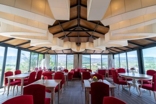 a restaurant with red chairs and tables and a large chandelier at Quinta da Terrincha in Torre de Moncorvo