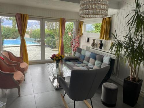 un soggiorno con divano e alcune sedie di Chez Rémy a Yverdon-les-Bains