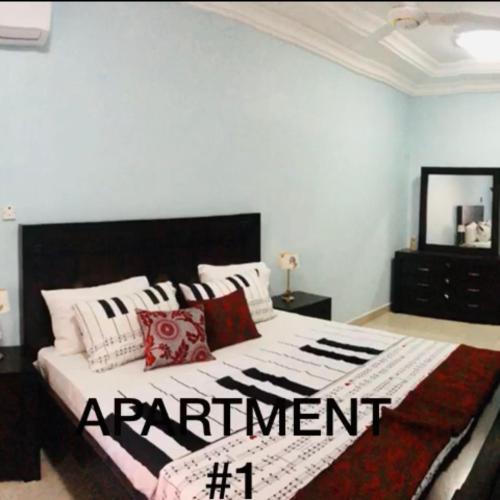 a bedroom with a large bed with a black and white blanket at Brusubee, phase 2 in Banjul