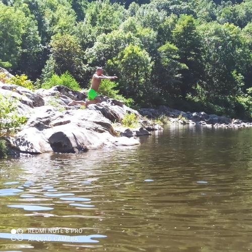 a man standing on a rock in the water at Chez Christian in Le Cheylard