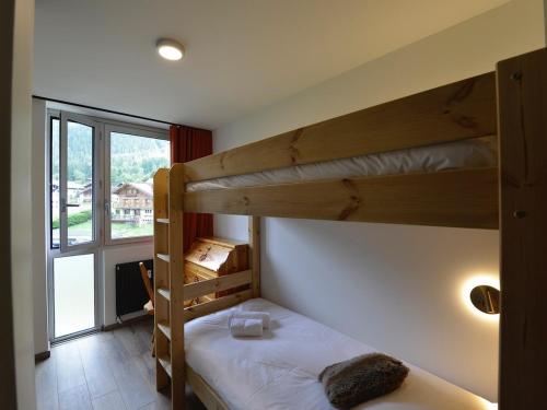 une chambre avec deux lits superposés et une fenêtre dans l'établissement T4 rénové avec vue Mont-Blanc, 4 étoiles, proche centre, parking - FR-1-507-62, à Chamonix-Mont-Blanc