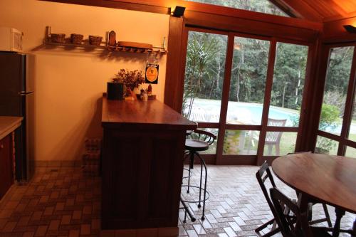 a kitchen with a counter and a table and a dining room at Casa do Fachoalto in Petrópolis