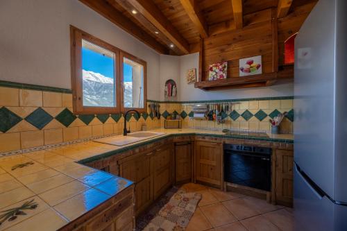 a kitchen with wooden cabinets and a window at Parenthèse Alpine - Barbecue - Terrasse - Parking in Enchastrayes