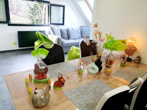 una sala de estar con una mesa con jarrones. en Bienvenue dans le chartreuse 2 à 6 couchages, en Cholonge