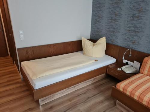 a small bed in a small room with a pillow at Hotel Stadt Witzenhausen in Witzenhausen